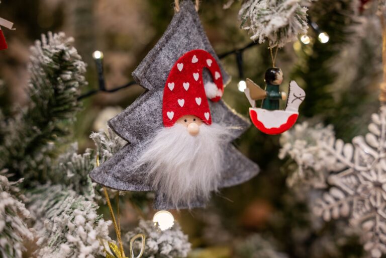 Close-up of charming holiday decorations on a Christmas tree with festive lights.