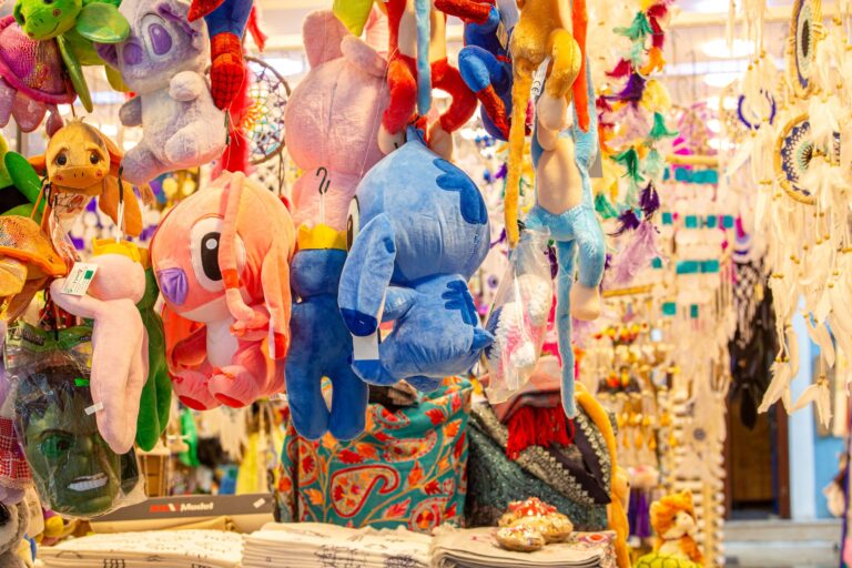Vibrant display of plush toys and dreamcatchers hanging in an indoor market.