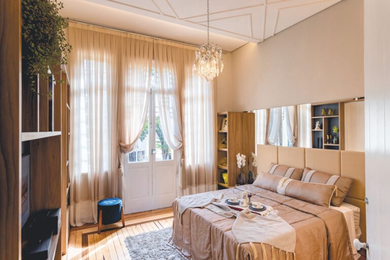 Cozy bedroom with elegant decor, soft lighting, and breakfast spread on bed, perfect for relaxation.