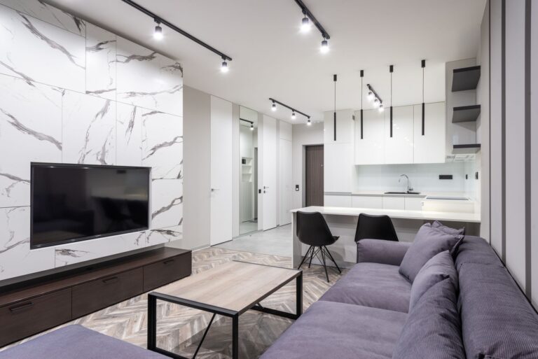 Stylish open-plan living room and kitchen with modern design elements and marble accents.