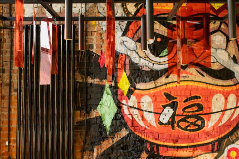Colorful graffiti mural with modern hanging lights creates a vibrant urban art decor.