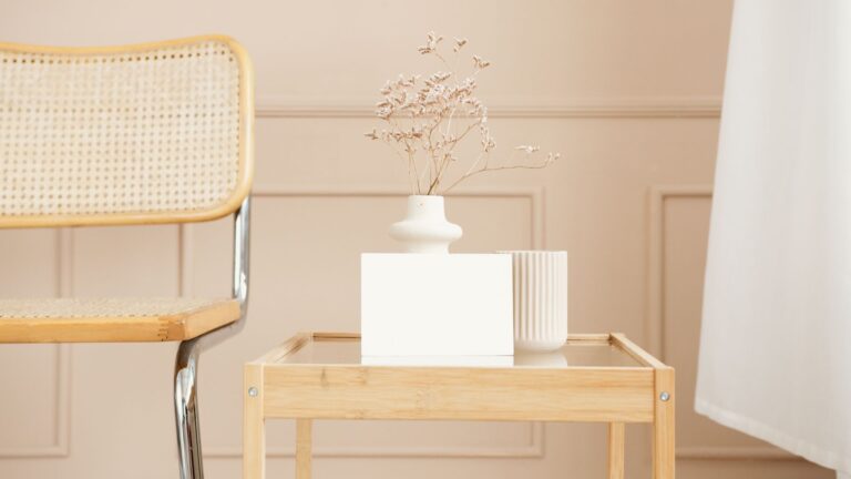 A minimalist interior featuring a wooden chair and table with elegant decor in soft pastel colors.