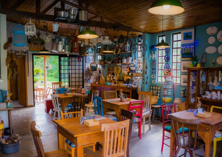 Cozy and vibrant rustic cafe interior in Cunha, Brazil, featuring eclectic decor and colorful wooden furniture.