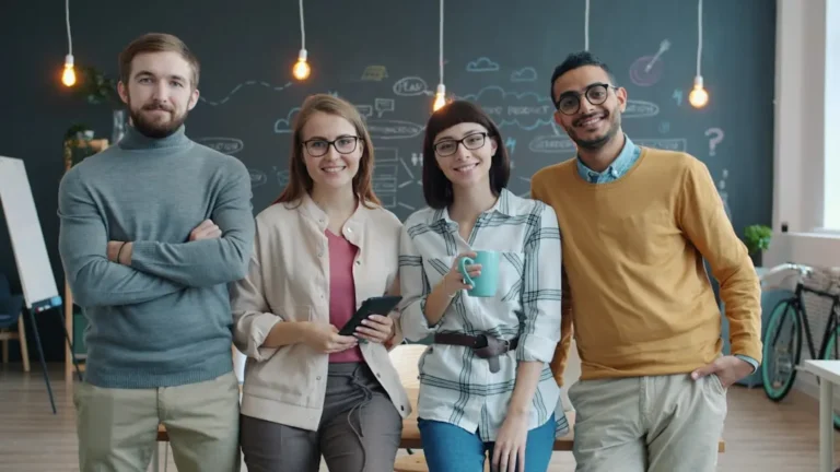 Quatro Pessoas Sorridentes Em Pe Em Um Escritorio Moderno E6rPqzAteII
