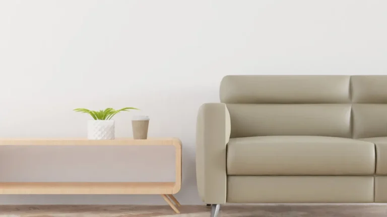Modern living room with a beige sofa, plant, and coffee cup on a stylish wooden table.