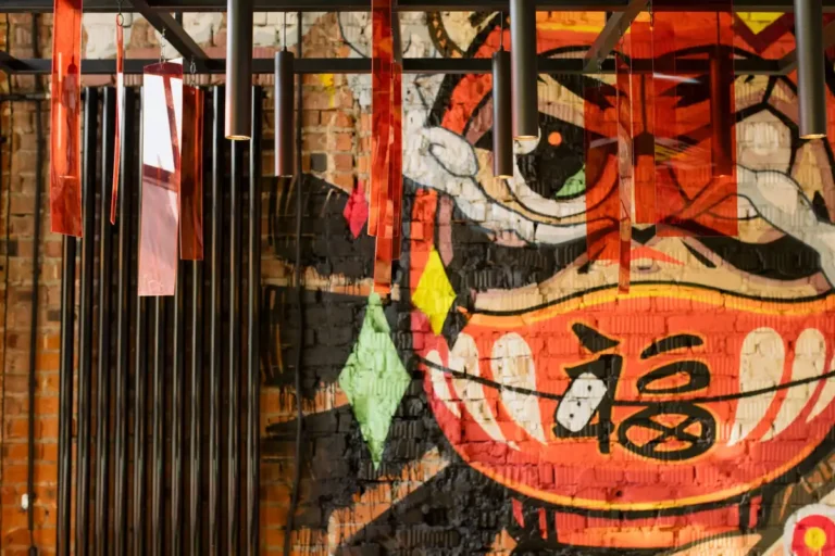 Colorful graffiti mural with modern hanging lights creates a vibrant urban art decor.