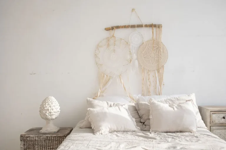 Charming rustic bedroom featuring a dreamcatcher, white bedding, and minimalist decor.